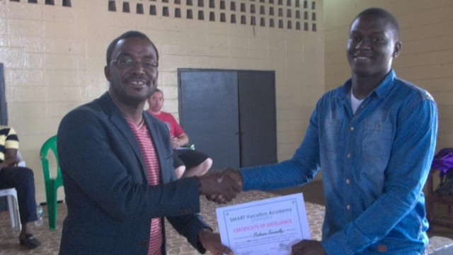 Minister George Werner presents a certificate to a student. Photo courtesy of SMART Liberia