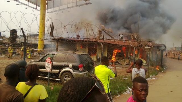 Crowds watch a building burn near the Red Light junction. Photo: Cyrus Sackie