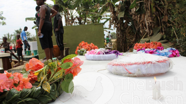 A burial vault at the Zuah Town Cemetery is decorated with wreaths, flowers, and a candle. 