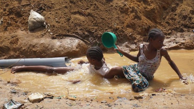Children playing in the water coming from the broken pipe. Photo: Zeze Ballah