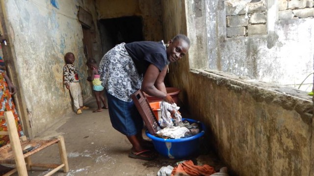 Another squatter, Mary Bernard, washes clothes in the hall at Catherine Mills. Photo: Zeze Ballah 